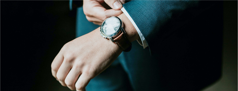 腕時計を触るスーツの男性